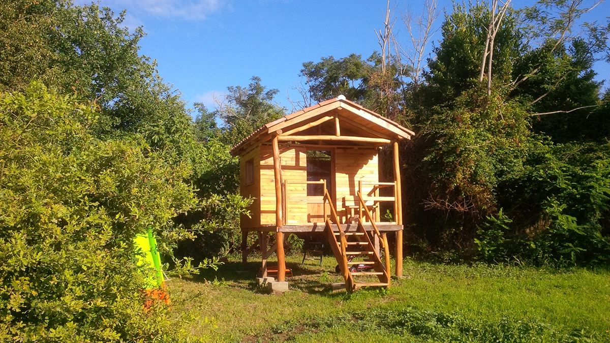 Cabane sur pilotis en sapin et rondins, escalier et terrasse