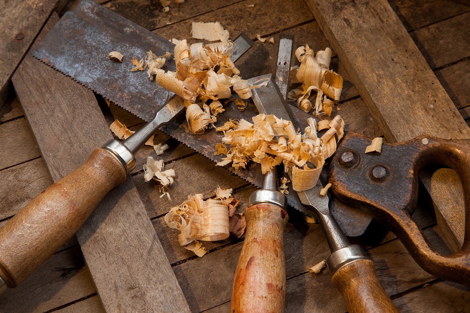 Établi de menuisier : scies égoïnes, ciseaux à bois et copeaux de rabot